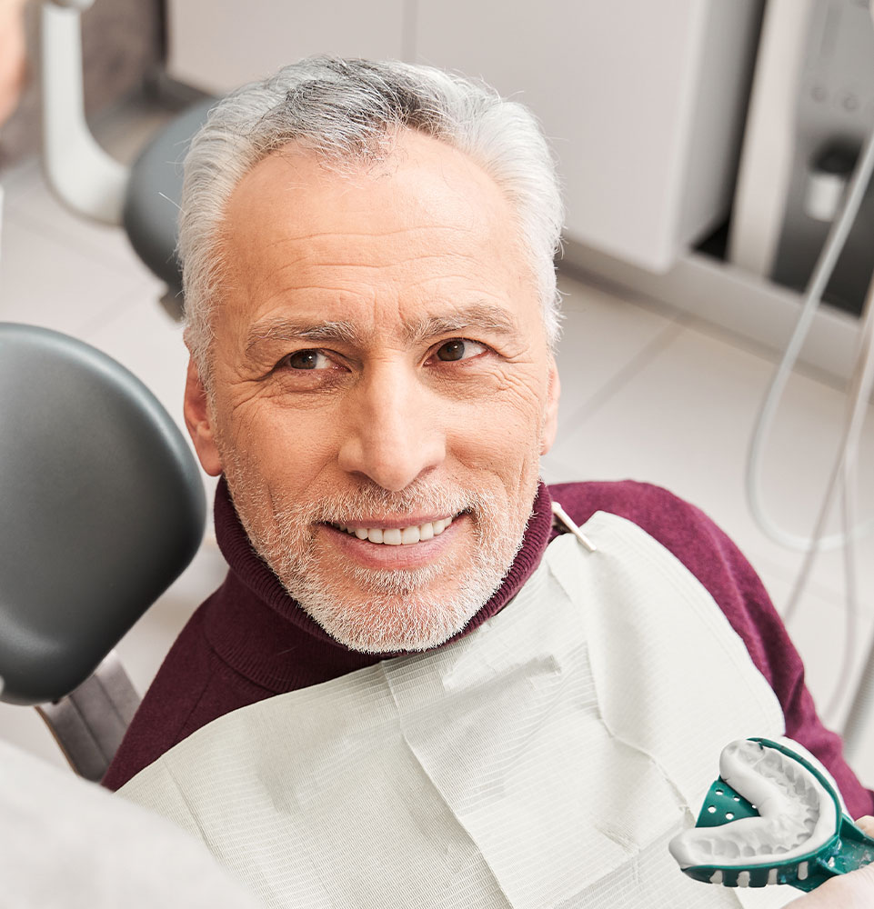 man getting fit for dentures mobile