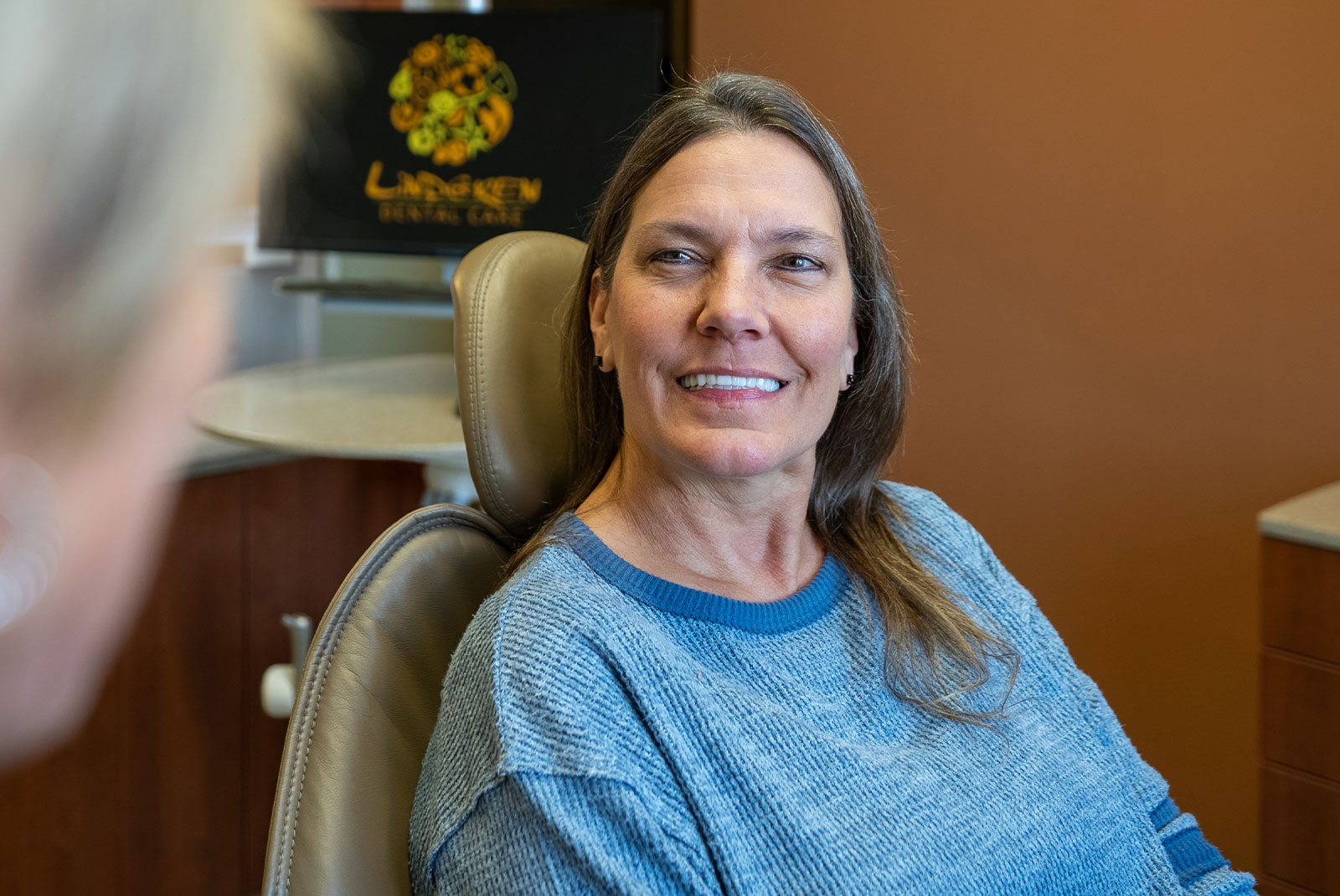 happy lady in blue sweater after dental work