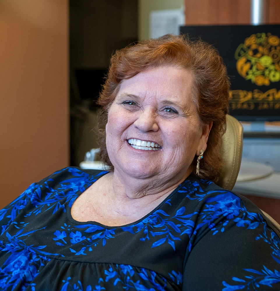 lady in blue black dress talking dental procedure mobile