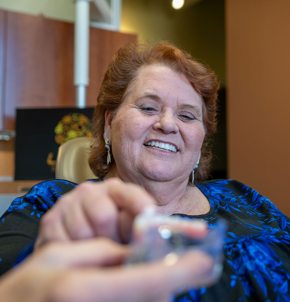 lady in black blue dress looks at dental implants