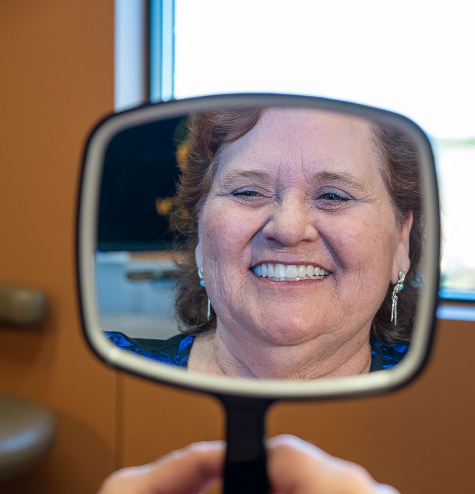 lady with mirror new dental implants