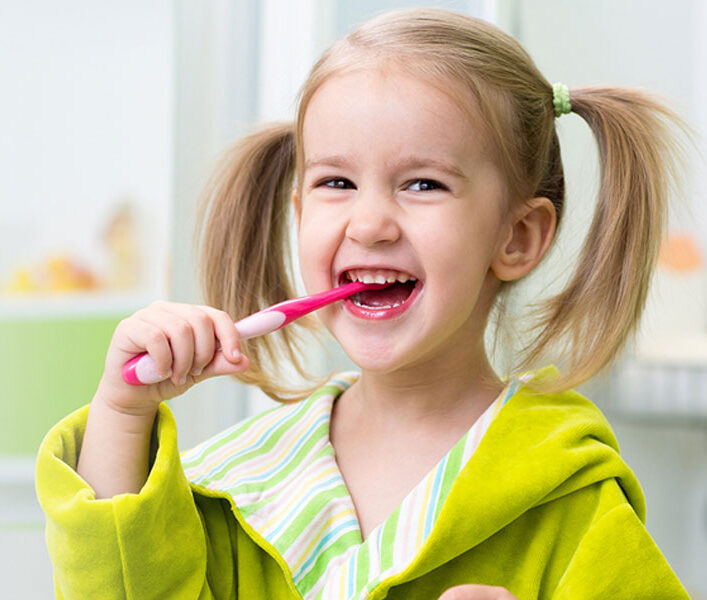 young kid brushing her teeth